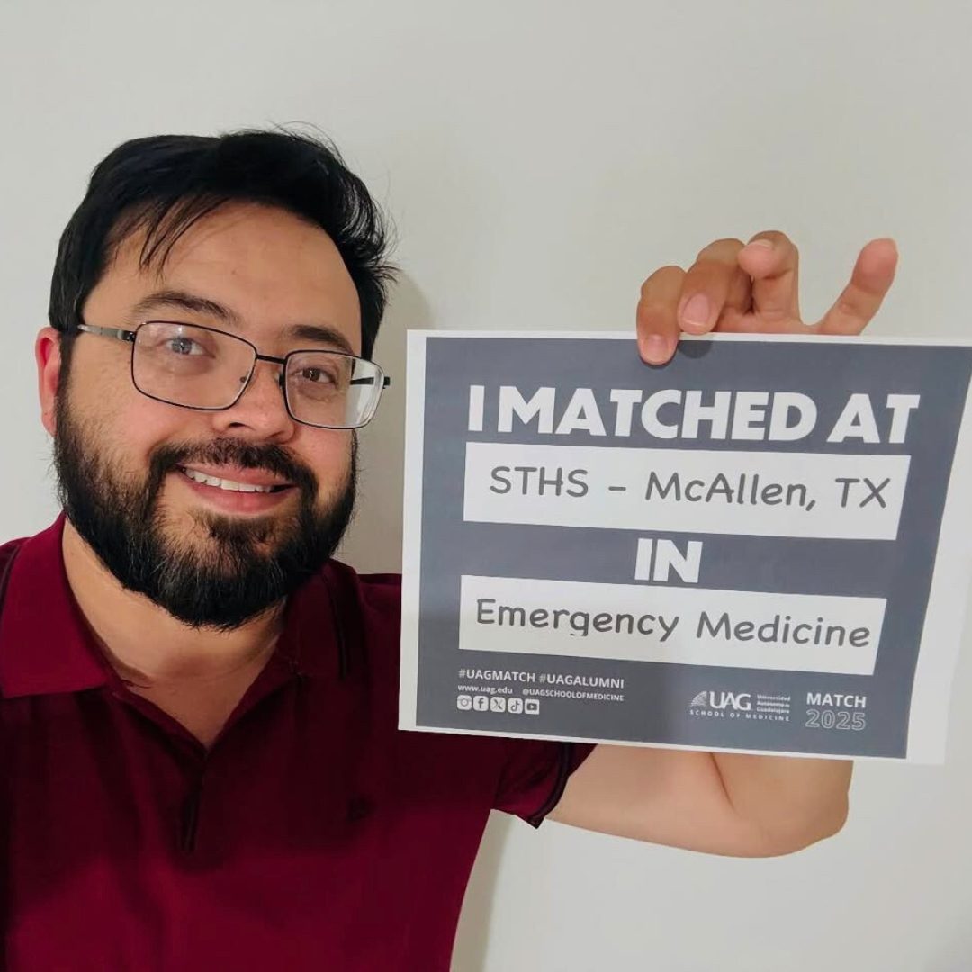 Man holds a sign "I matched at STIS McCallen" celebrating Residency Success in GEO Miami